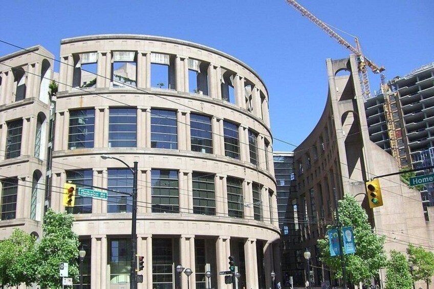 A curved building with multiple windows, a street sign, traffic lights, and a construction crane in the background. 4