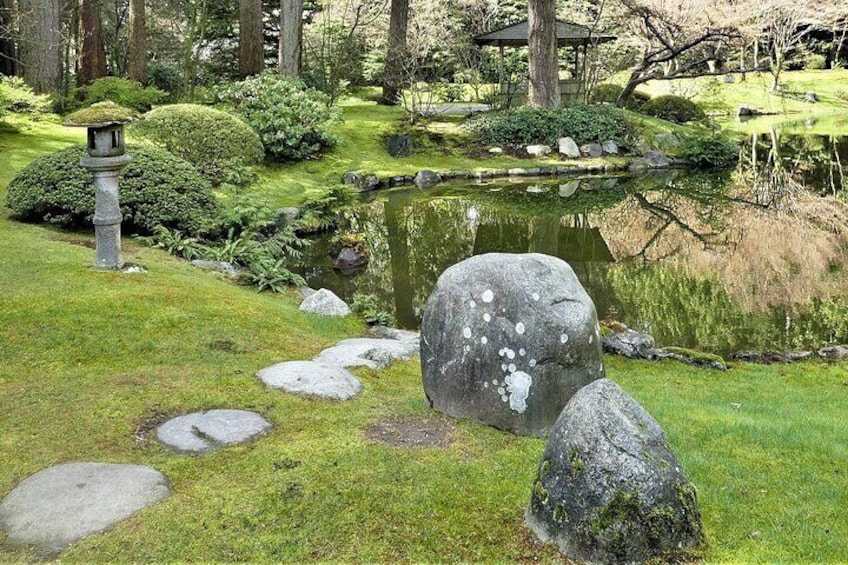 A serene garden with a pond, stepping stones, a stone lantern, and a pagoda. 3