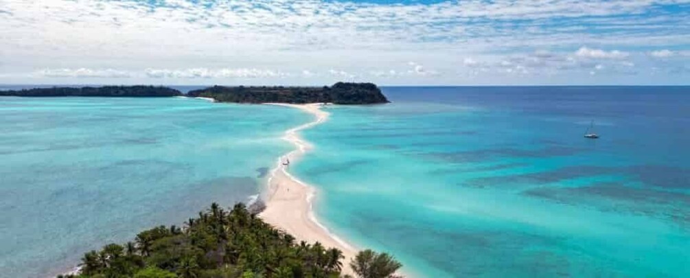 A turquoise sea, a sandy beach, and a small island in the distance. 1