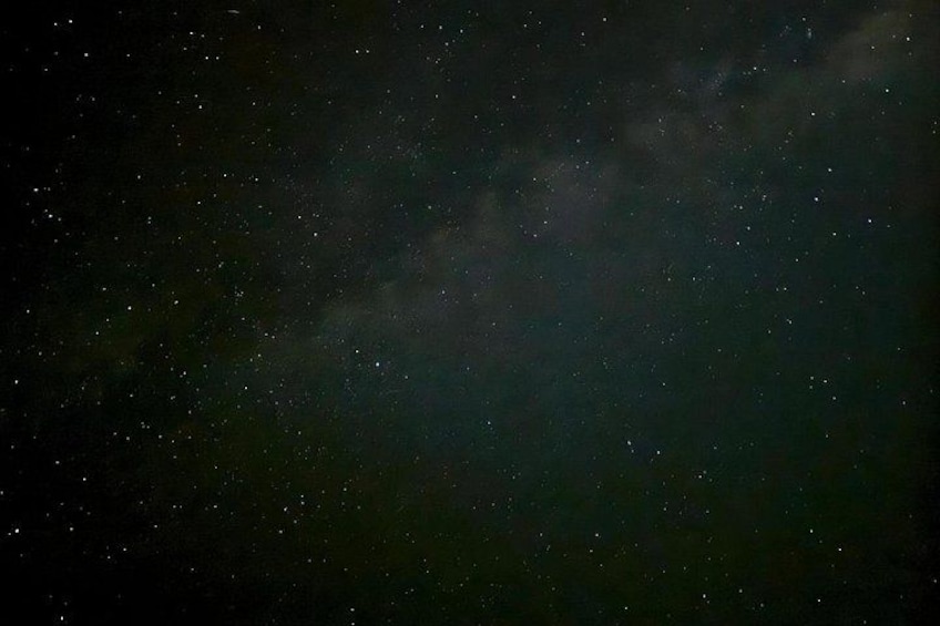 A starry night sky with visible stars and a faintly visible galaxy. 3