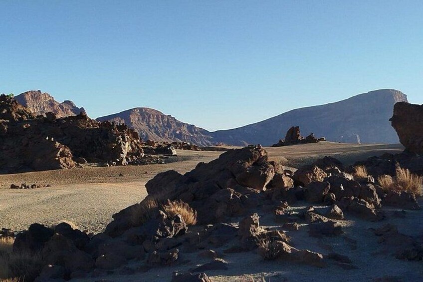 A desert landscape with rocky terrain and distant mountains. 5