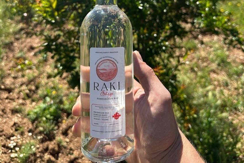 A hand holding a bottle of Raki Pomegranate Bar. 3