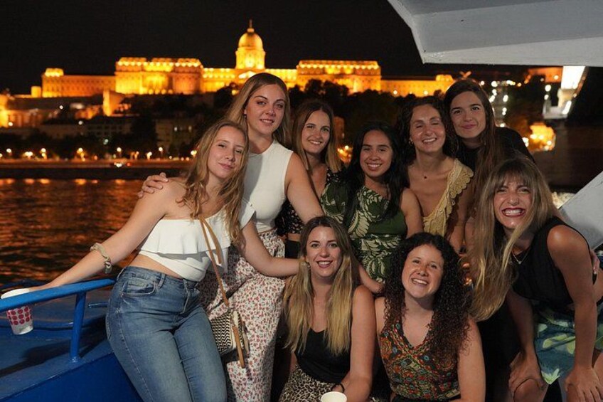 A group of people on a boat with a cityscape in the background. 3