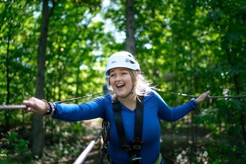 A person on a zip line in a forest. 1