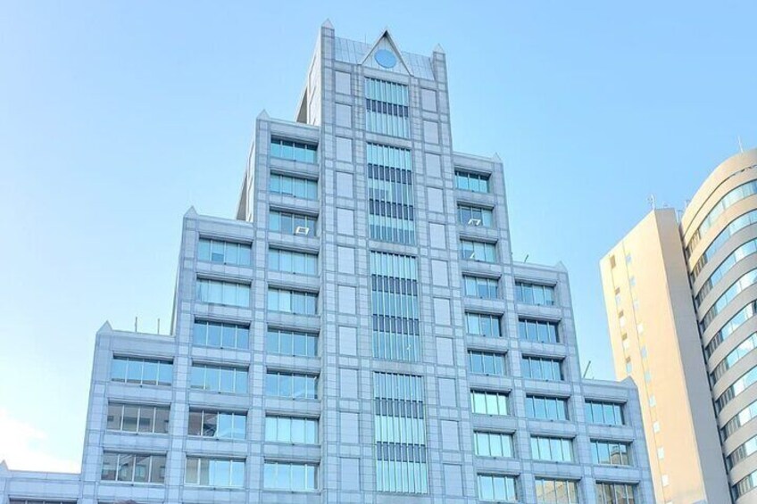 A modern high-rise building with a distinctive triangular top and multiple windows. 3