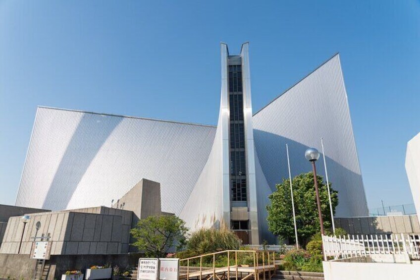 A modern building with a unique geometric design, featuring a tall central tower and expansive, angled wings. 2