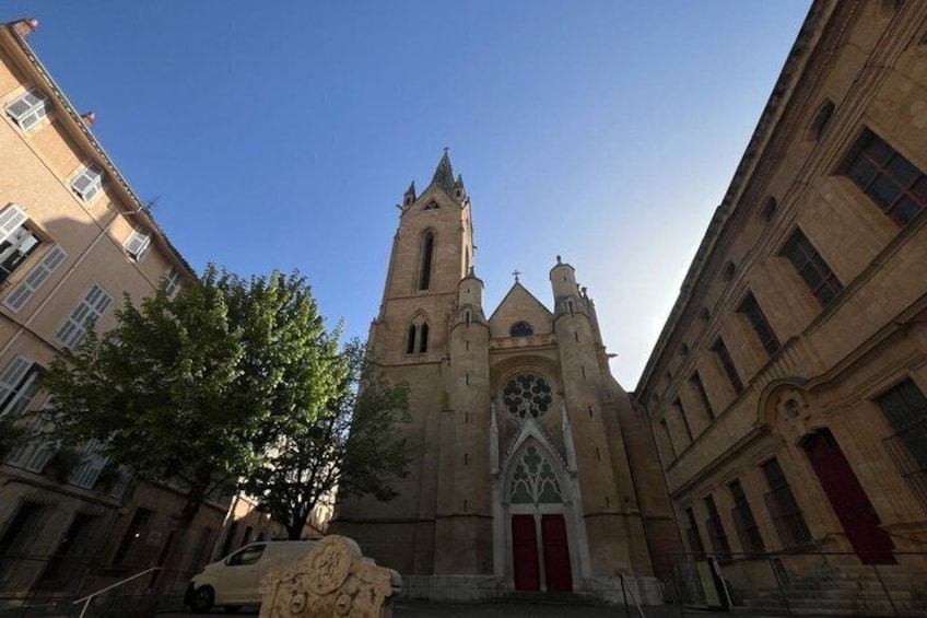 A historic church with a tall bell tower and a large rose window. 3