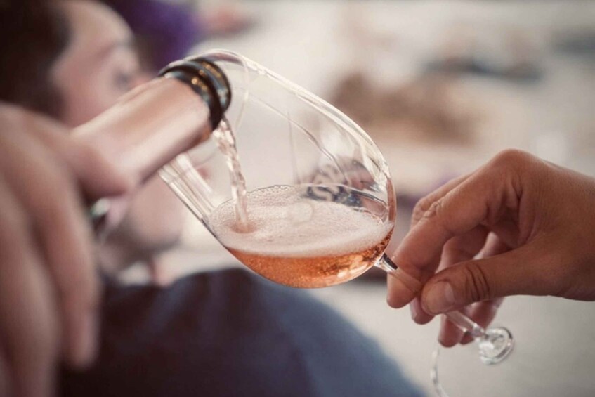A person pouring a drink from a glass. 5