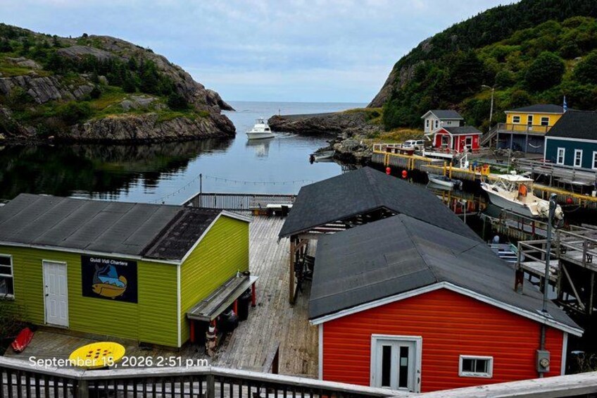 A coastal village with colorful buildings, a dock, and a boat. 1