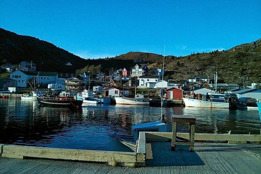 A harbor with boats, a wooden dock, and buildings in the background. 5
