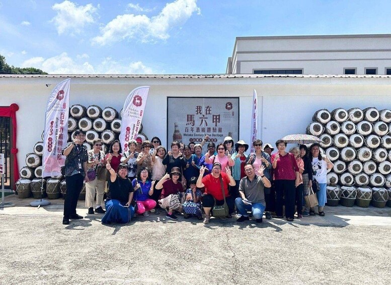 A group of people posing in front of a building with banners and a signboard. 3