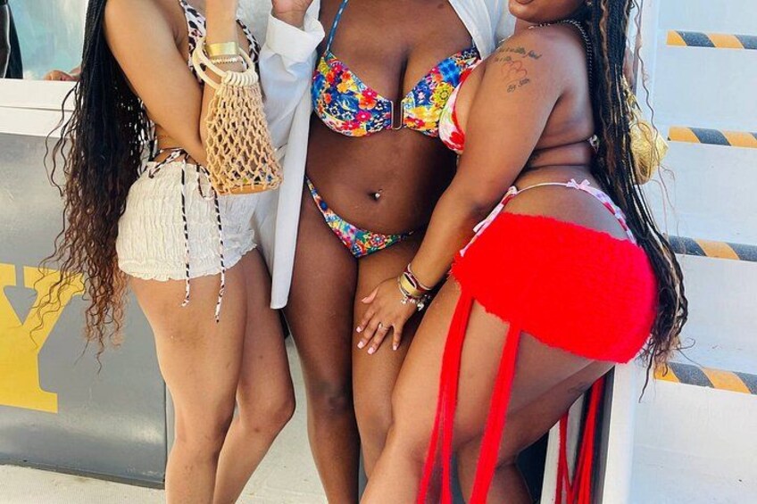 Three people in swimwear, one in a white top and shorts, another in a colorful bikini, and the third in red swim bottoms. 3