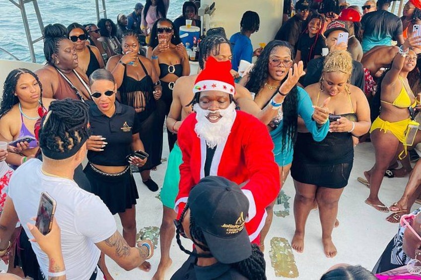 A crowded outdoor event with people in festive attire, including a person in a Santa costume. 2