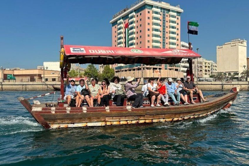 A boat with 'Dubai' written on the side, passengers on board, and a cityscape in the background. 2