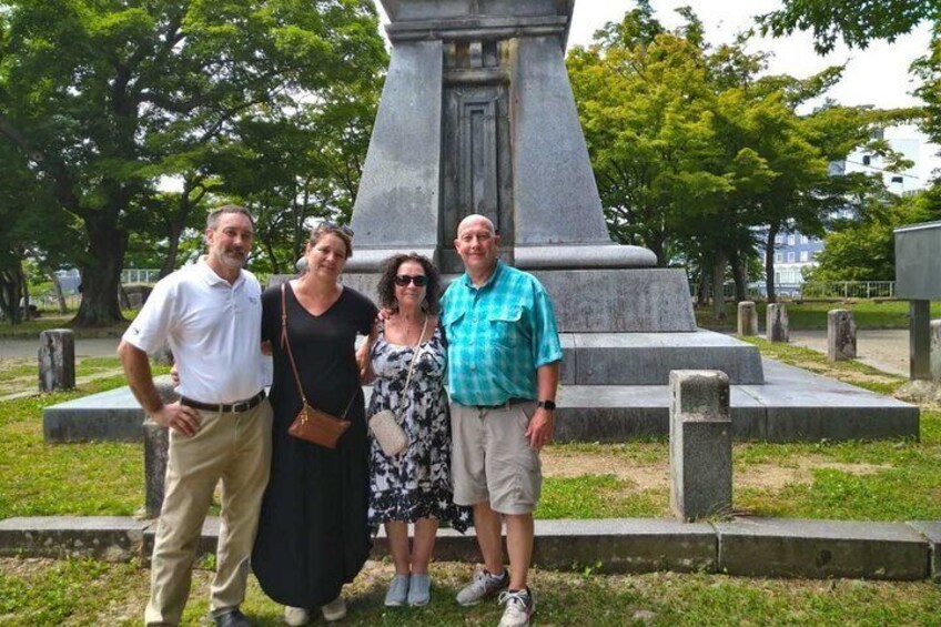 A group of people standing in front of a monument in a cemetery. 3