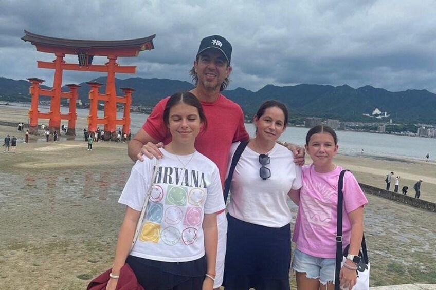 A family at a beach with a torii gate in the background. 3