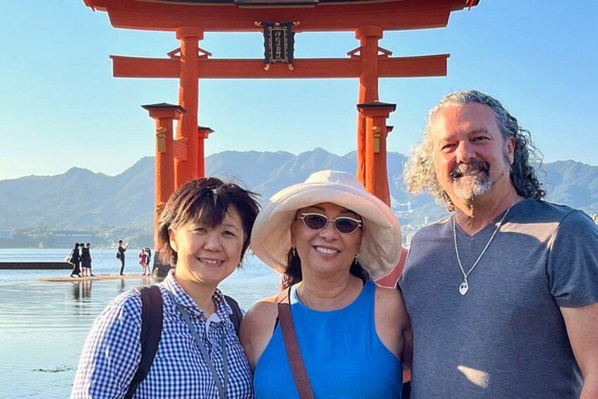 A red torii gate, a person in a blue top, and a person in a checkered shirt. 1