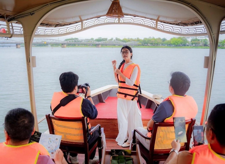 A boat with passengers wearing life jackets, a person taking a photo, and a view of a river with greenery in the background. 4