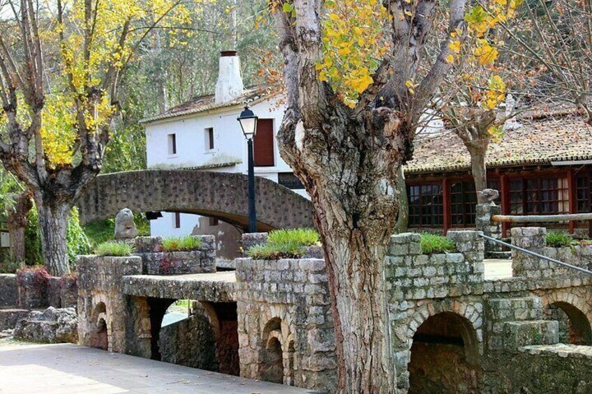 A stone bridge, a white building, and a tree with yellow leaves. 3