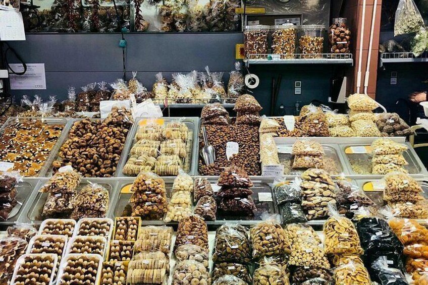A variety of nuts and dried fruits displayed in trays and bags. 4