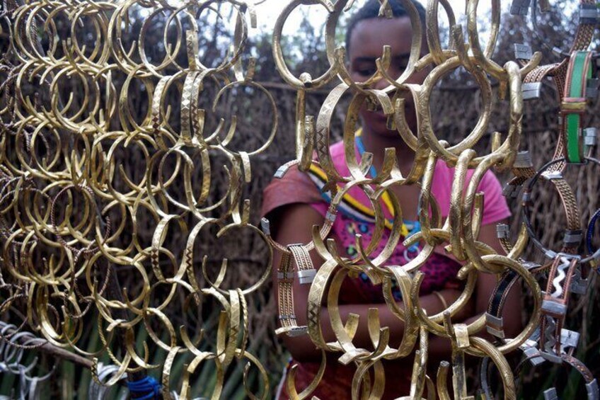 A person behind a fence of interlocking golden rings. 3