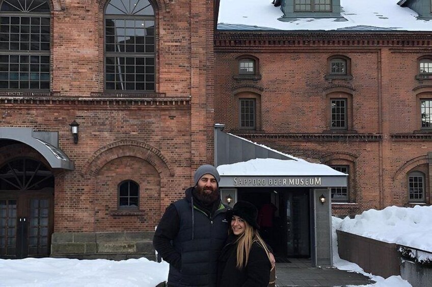 A brick building with a sign that reads 'Sapporo Beer Museum' and snow on the ground. 2
