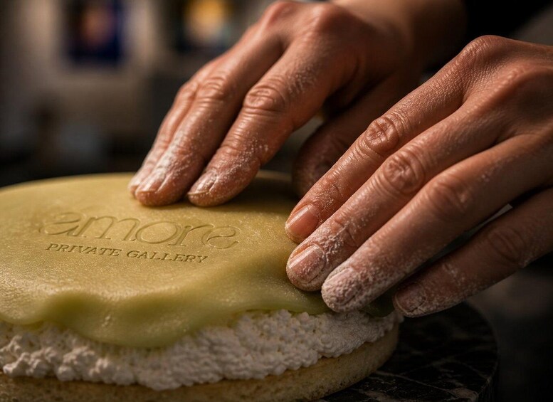 Hands shaping a pastry with 'amore PRIVATE GALLERY' embossed on it. 2