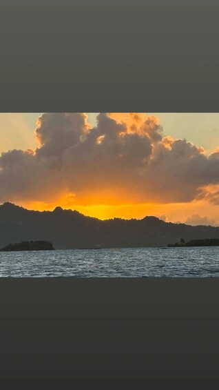 A sunset over a body of water with mountains in the background. 4