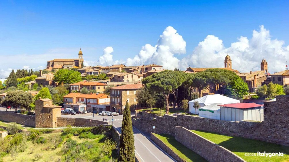 A historic town with stone buildings, a prominent church, and a castle wall. 3