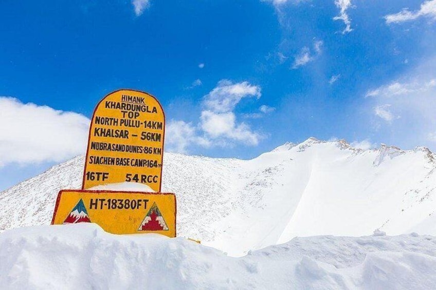 A mountain peak sign with information about various mountain names and distances. 4