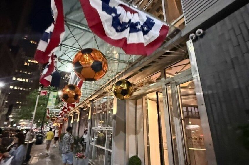 A street decorated with hanging flags and soccer balls. 4