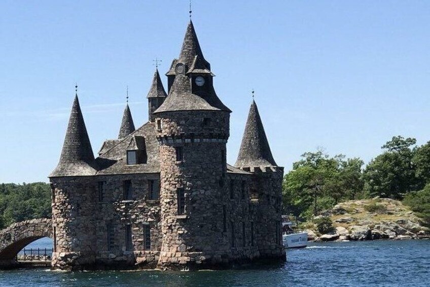 A stone castle with multiple towers by a body of water. 3