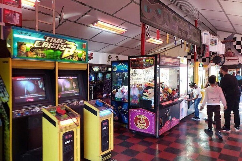 An arcade with various gaming machines, including a 'Time Crisis 3' game. 2