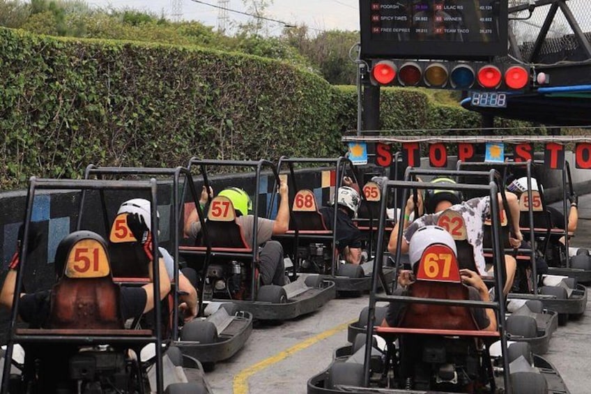 A group of people in go-karts at a race track. 4