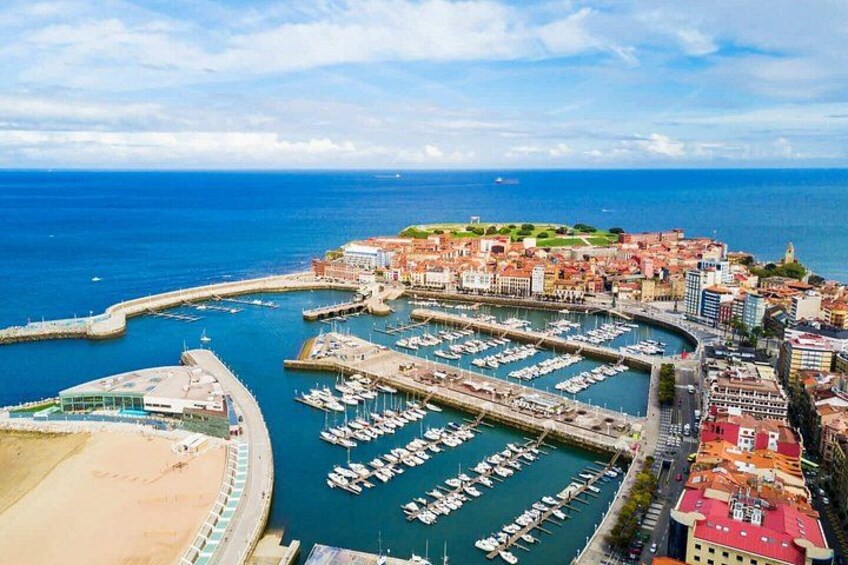 A coastal town with a marina, buildings, and a beach. 5