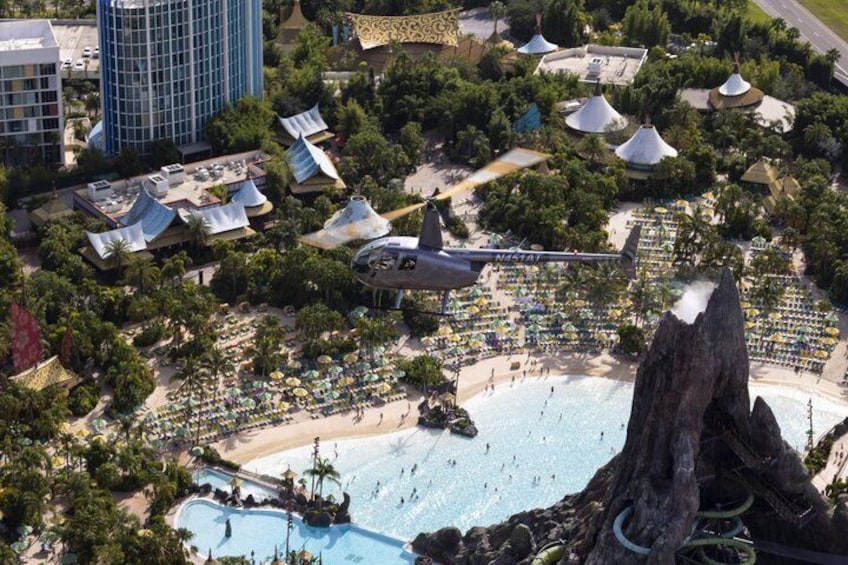 A resort with a large pool, beach, and a helicopter landing pad. 1