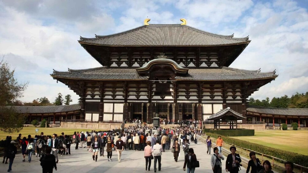 A traditional Japanese building with a large crowd in front. 2