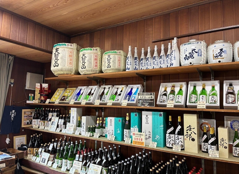 Shelves stocked with various bottles of sake and other alcoholic beverages, with price tags visible. 1