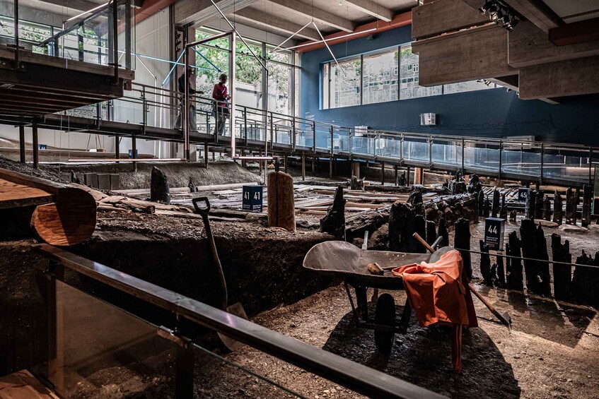 An excavation site with exposed earth, wooden planks, and construction materials. 4