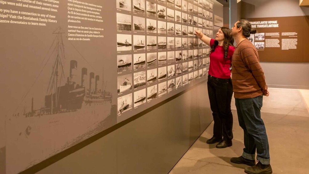 A museum exhibit with a large wall of historical ship images and a detailed ship illustration. 3
