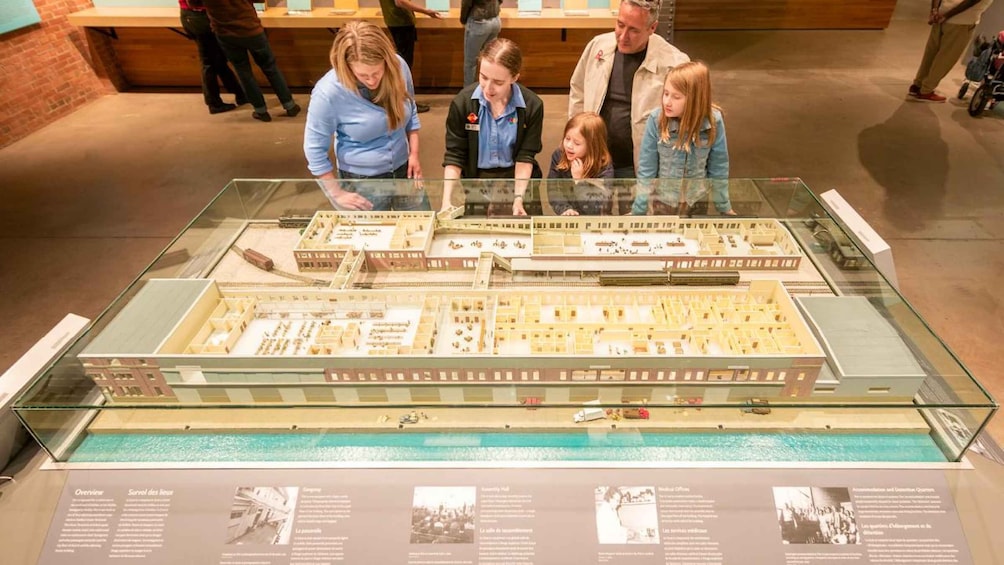 A model of a building complex with multiple structures, a swimming pool, and informational panels. 4