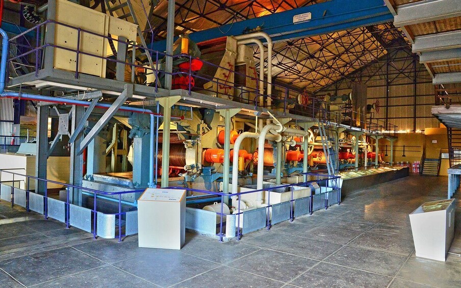 En industriel bygning med store maskiner, metalkonstruktioner og et hvælvet loft. 5