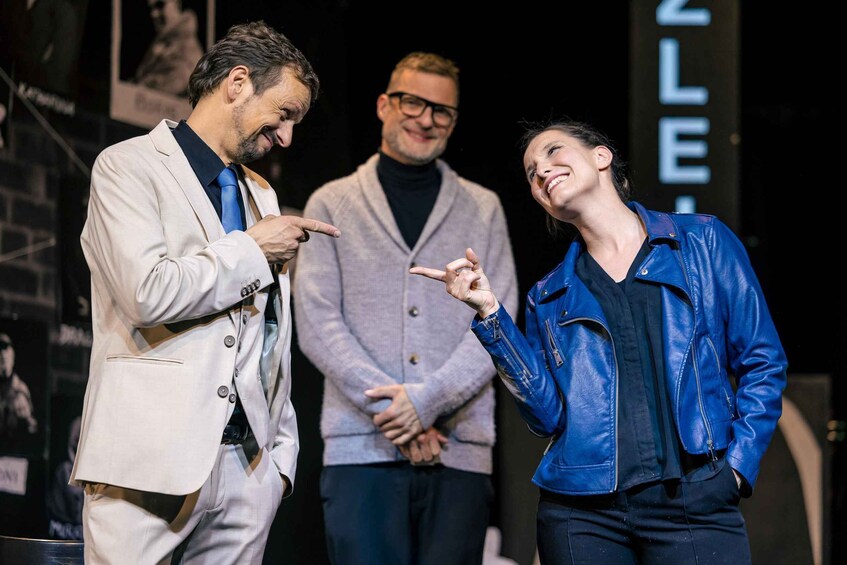 Three people on a stage with a banner in the background. 4