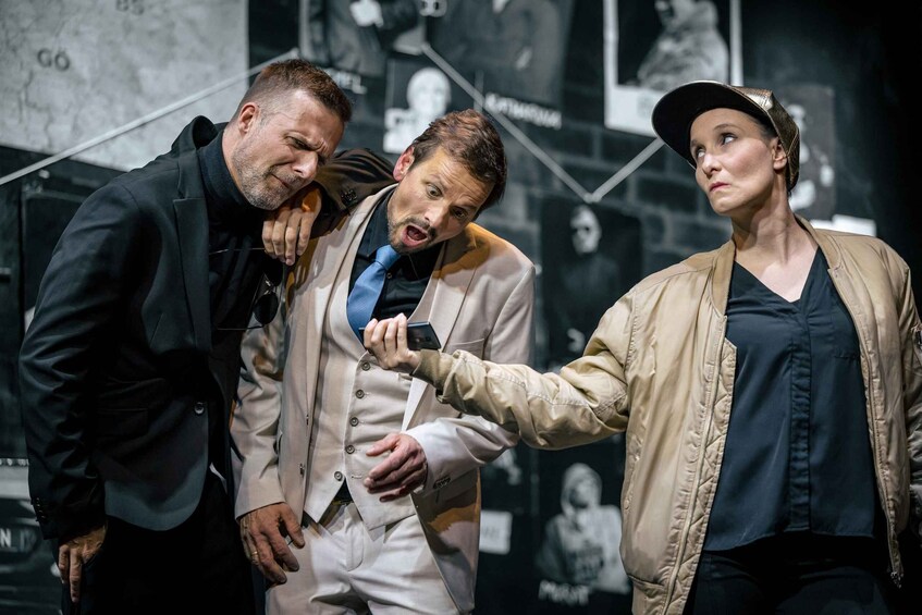 Three people in a room with a dark background and a map. 2