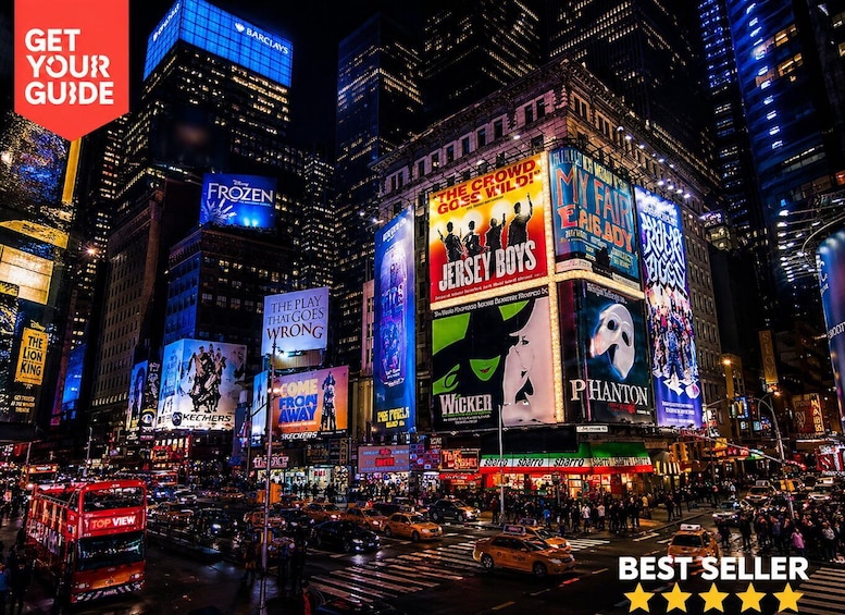 A busy city intersection with illuminated billboards advertising various shows and products. 1