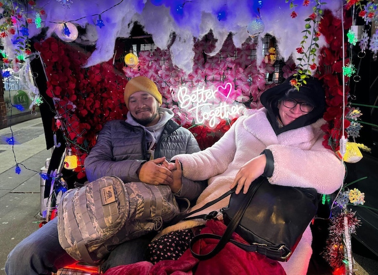 Two people sitting on a bench with a decorative backdrop and a neon sign that reads 'Better Together.' 5