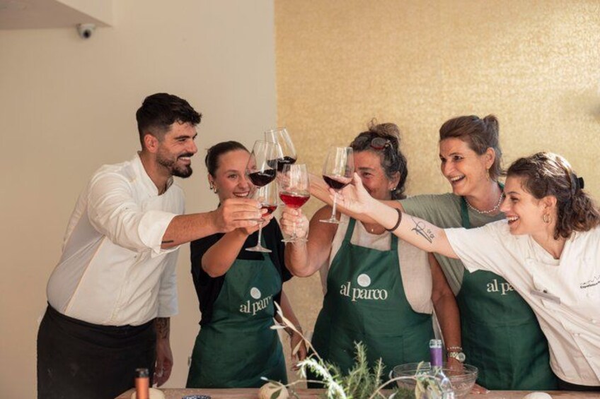 A group of people toasting with wine glasses at a table. 1