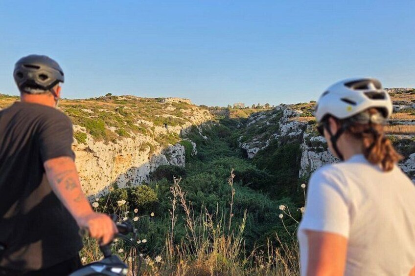 Two people on bicycles, a rocky landscape, and a clear sky. 3
