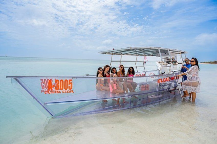A group of people on a boat with a clear canopy, labeled 'Cox 8005,' in a calm sea. 4