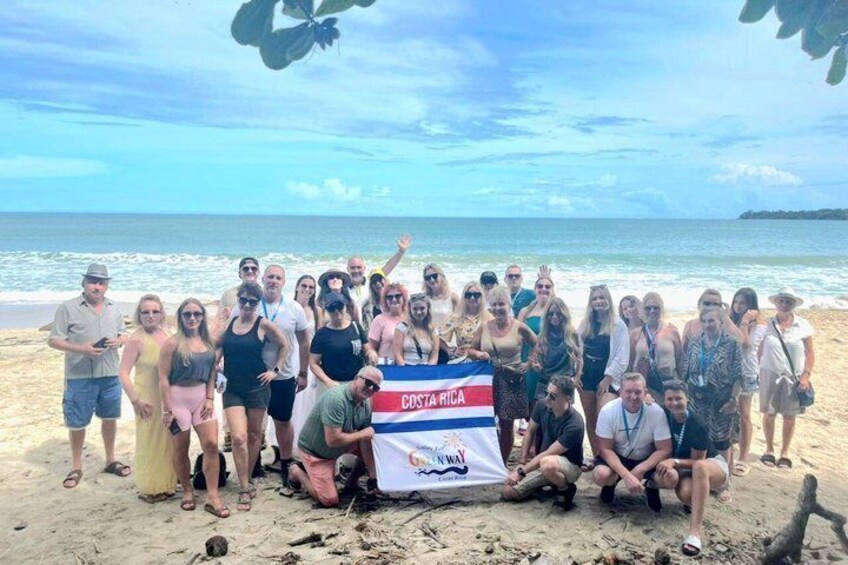 A group of people on a beach with a flag labeled 'Costa Rica.' 1